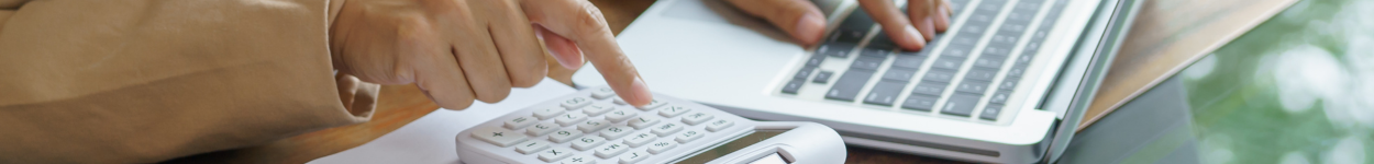 Hands typing on a calculator
